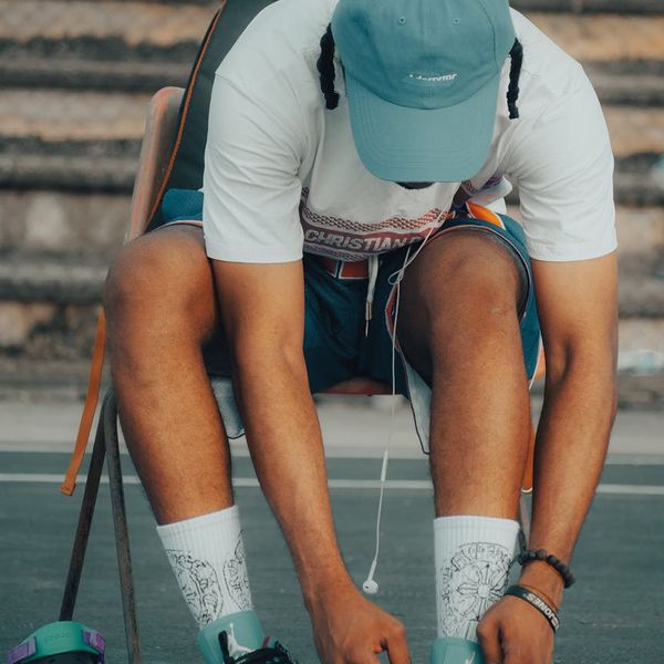 Person tying their shoelaces before a morning walk in the city.